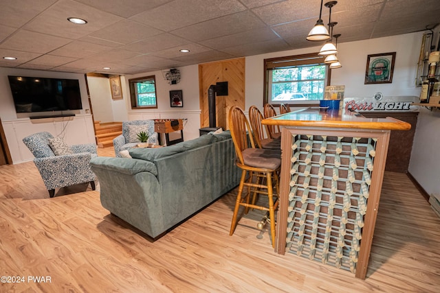 living room featuring a paneled ceiling and light hardwood / wood-style floors