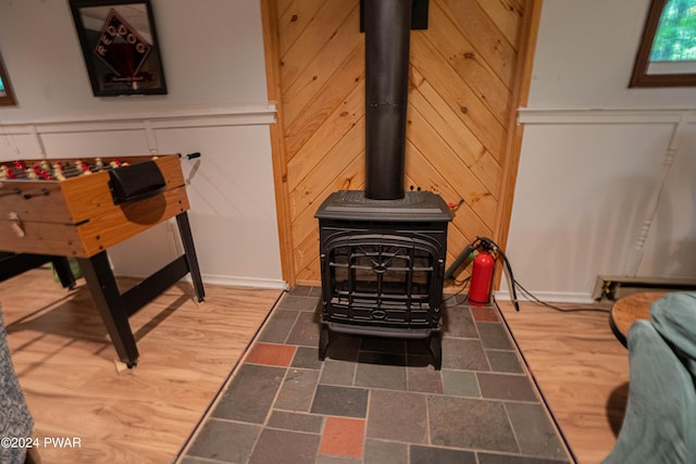 interior details featuring a wood stove and wood walls