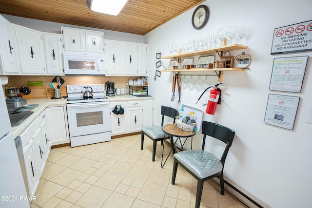 kitchen featuring tasteful backsplash, white appliances, light tile patterned floors, wooden ceiling, and white cabinetry