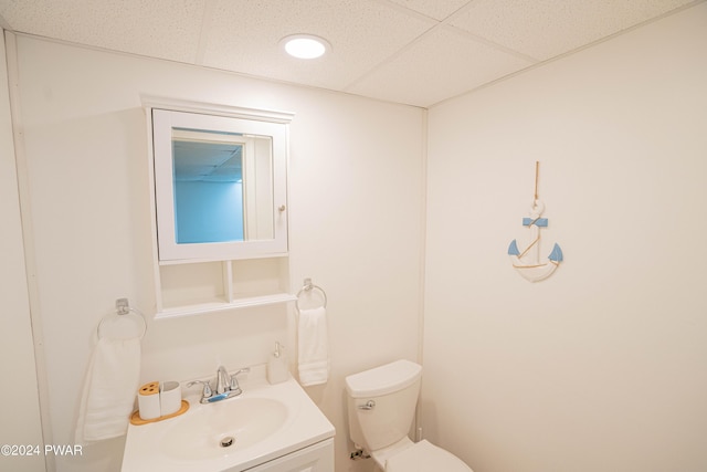 bathroom with vanity, a paneled ceiling, and toilet