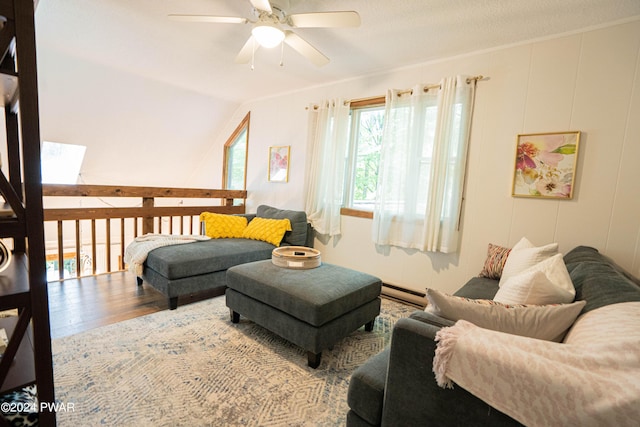 living room featuring hardwood / wood-style flooring, baseboard heating, ceiling fan, and crown molding