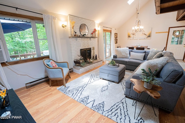 70 Underwood Ln, Lake Ariel, PA 18436 - living room with baseboard heating, a chandelier, wood-type flooring, lofted ceiling, and a fireplace
