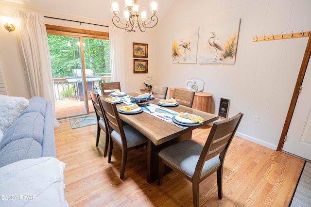 dining room with vaulted ceiling, a notable chandelier, and light wood-type flooring