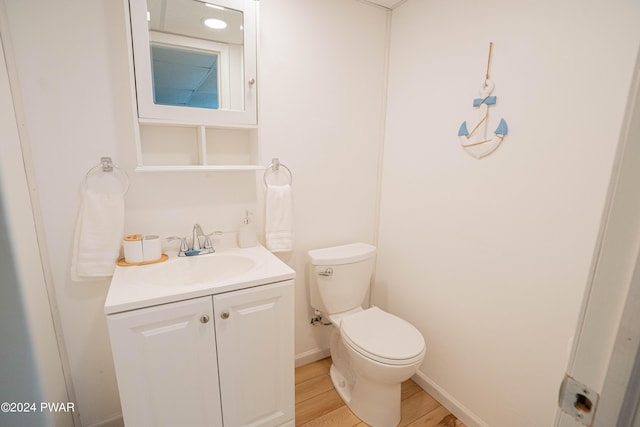 bathroom with hardwood / wood-style floors, vanity, and toilet