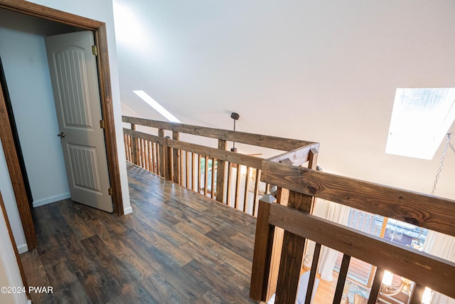 hall with a skylight and dark wood-type flooring