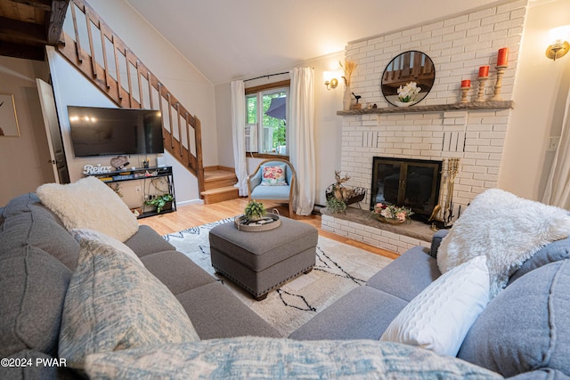 living room with a fireplace, light wood-type flooring, and lofted ceiling