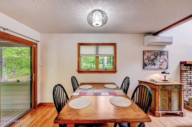 105 Chestnut Ct, Lackawaxen, PA 18435 - dining room featuring a wall mounted air conditioner, light wood-style floors, a textured ceiling, and baseboards