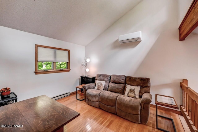 105 Chestnut Ct, Lackawaxen, PA 18435 - living area featuring an AC wall unit, a baseboard heating unit, vaulted ceiling, and light wood finished floors