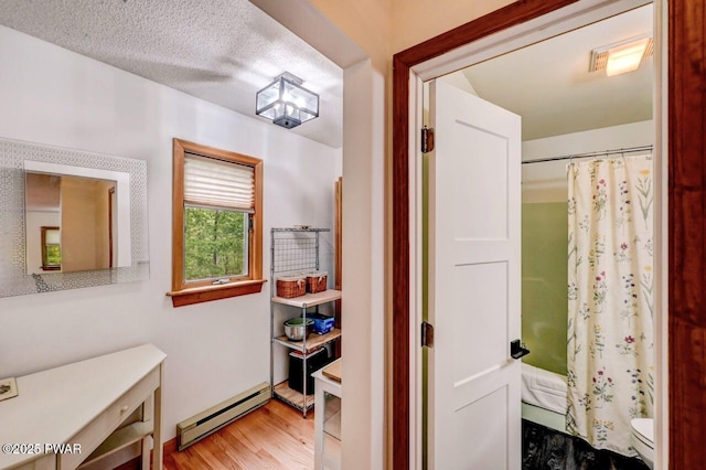 105 Chestnut Ct, Lackawaxen, PA 18435 - bathroom featuring a baseboard heating unit, toilet, wood finished floors, a shower with shower curtain, and vanity