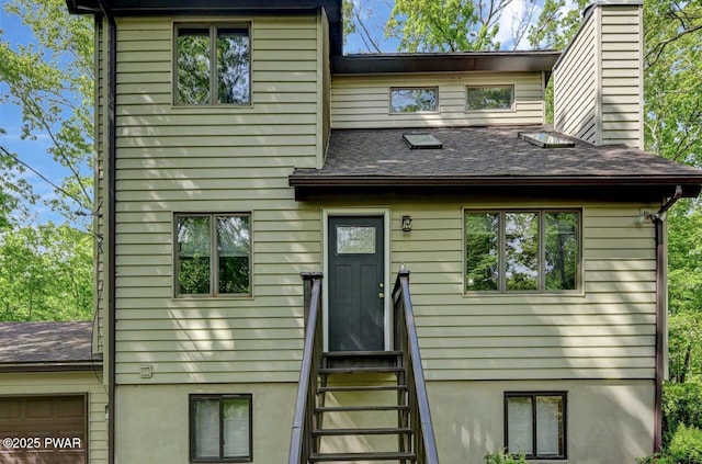 105 Chestnut Ct, Lackawaxen, PA 18435 - view of front of house with entry steps, a chimney, a shingled roof, and a garage