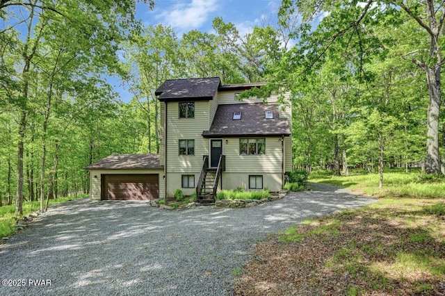 105 Chestnut Ct, Lackawaxen, PA 18435 - view of front of property with gravel driveway, an attached garage, a view of trees, and roof with shingles
