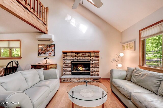 105 Chestnut Ct, Lackawaxen, PA 18435 - living room featuring a wall mounted AC, ceiling fan, plenty of natural light, wood finished floors, and high vaulted ceiling