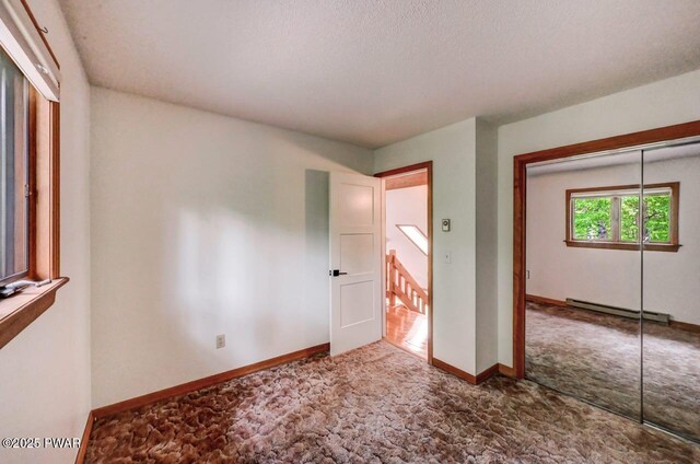 105 Chestnut Ct, Lackawaxen, PA 18435 - unfurnished bedroom featuring baseboard heating, carpet, a closet, and baseboards
