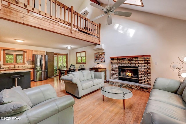 105 Chestnut Ct, Lackawaxen, PA 18435 - living area featuring a wall mounted air conditioner, light wood-type flooring, a towering ceiling, ceiling fan, and a fireplace