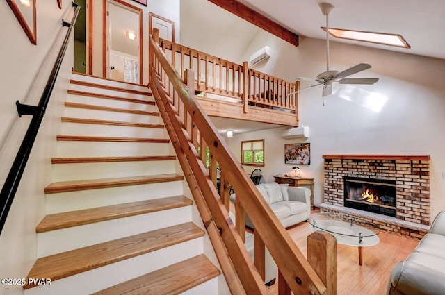 105 Chestnut Ct, Lackawaxen, PA 18435 - stairs with wood finished floors, a wall mounted AC, a ceiling fan, beamed ceiling, and a brick fireplace