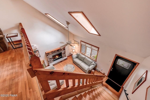 105 Chestnut Ct, Lackawaxen, PA 18435 - stairway featuring wood finished floors, ceiling fan, vaulted ceiling, a brick fireplace, and a skylight