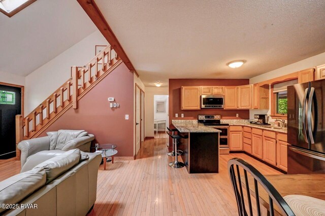 105 Chestnut Ct, Lackawaxen, PA 18435 - kitchen featuring stainless steel appliances, light brown cabinets, a kitchen breakfast bar, light wood finished floors, and open floor plan