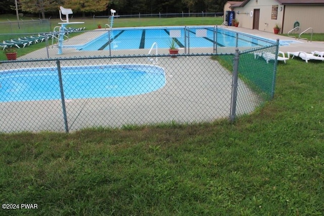 view of swimming pool with a lawn