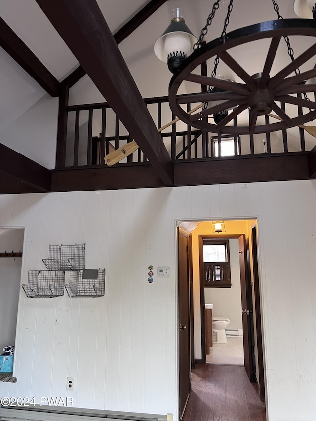 hall with beam ceiling, wood walls, and dark wood-type flooring