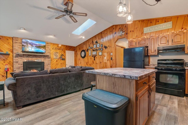 kitchen with black appliances, a kitchen island, a fireplace, vaulted ceiling, and ceiling fan