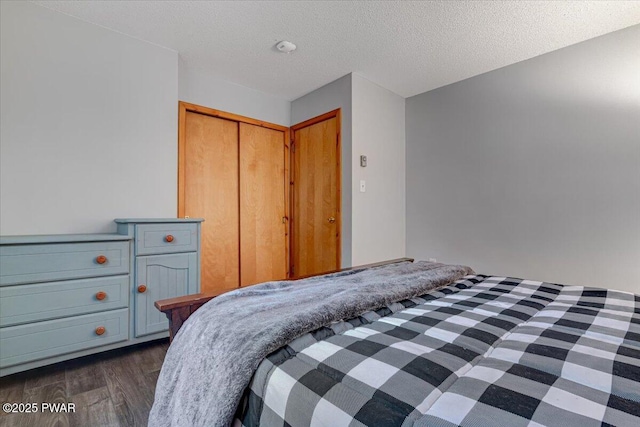 unfurnished bedroom with a textured ceiling, a closet, and dark hardwood / wood-style flooring