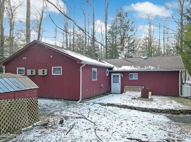 view of snow covered rear of property