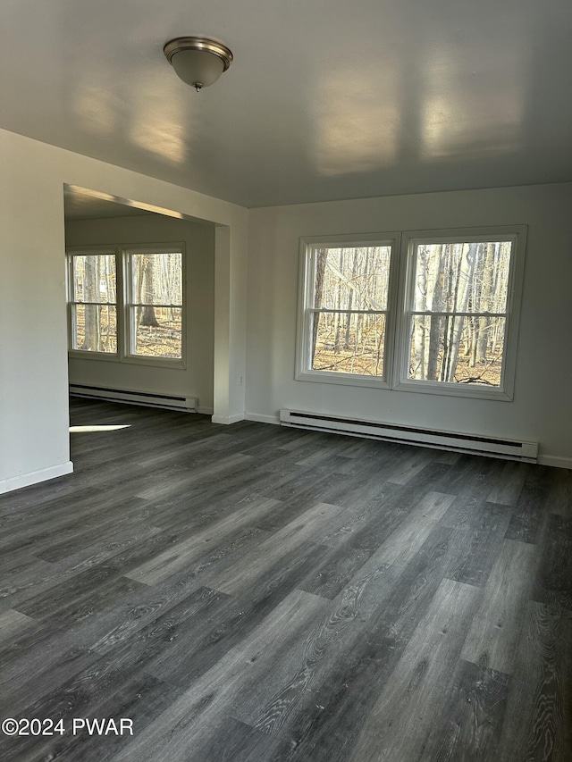 spare room featuring a baseboard radiator and dark wood-type flooring