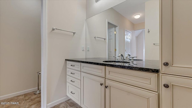 bathroom with vanity, baseboards, and tile patterned floors