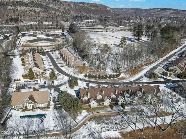 snowy aerial view with a mountain view and a residential view