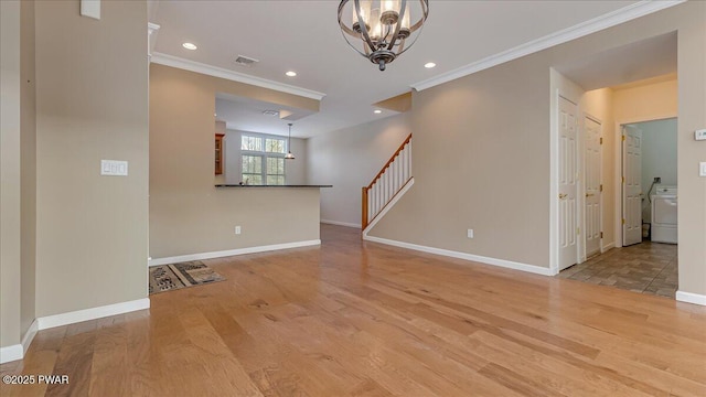 spare room with light wood-style floors, baseboards, visible vents, and crown molding