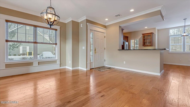 entrance foyer featuring light wood-style flooring, visible vents, baseboards, and ornamental molding