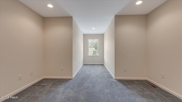 empty room featuring dark colored carpet, recessed lighting, visible vents, and baseboards