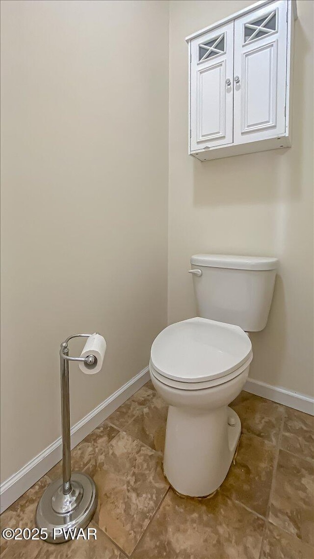 bathroom with toilet and baseboards