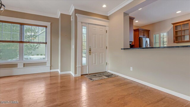 entrance foyer featuring light wood-type flooring, recessed lighting, baseboards, and ornamental molding