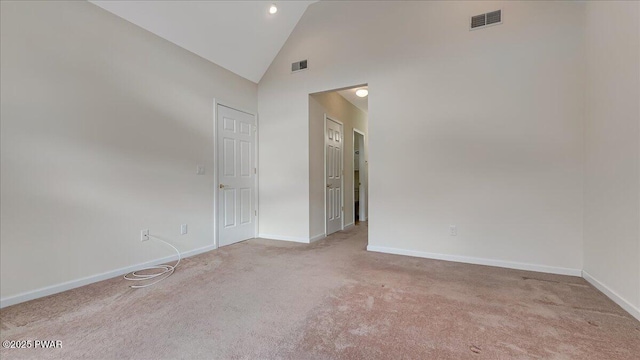 spare room featuring high vaulted ceiling, baseboards, and visible vents