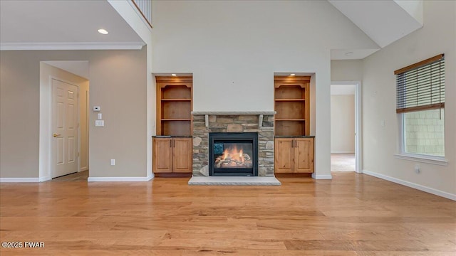 unfurnished living room featuring high vaulted ceiling, baseboards, a stone fireplace, and light wood finished floors