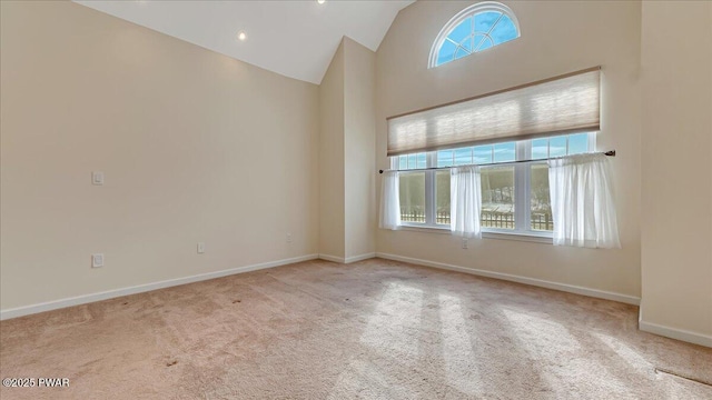 unfurnished room with baseboards, high vaulted ceiling, and light colored carpet