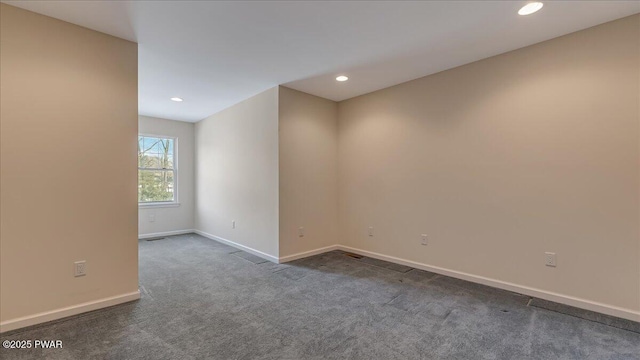 spare room with dark colored carpet, baseboards, and recessed lighting