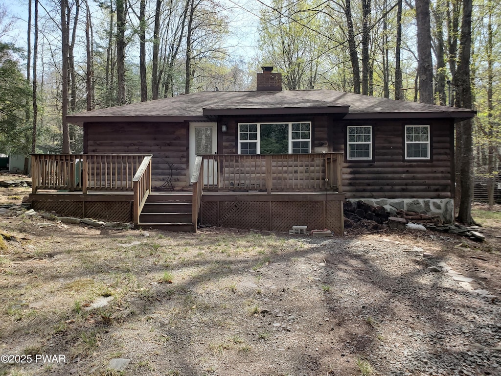 103 Hickory Dr, Greentown, PA 18426 - view of front of house with log veneer siding, a chimney, a shingled roof, and a wooden deck