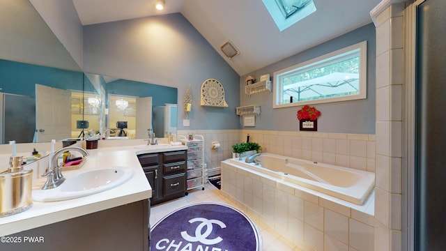 785 Milford Rd, Dingmans Ferry, PA 18328 - bathroom featuring a skylight, vanity, a garden tub, tile patterned floors, and vaulted ceiling