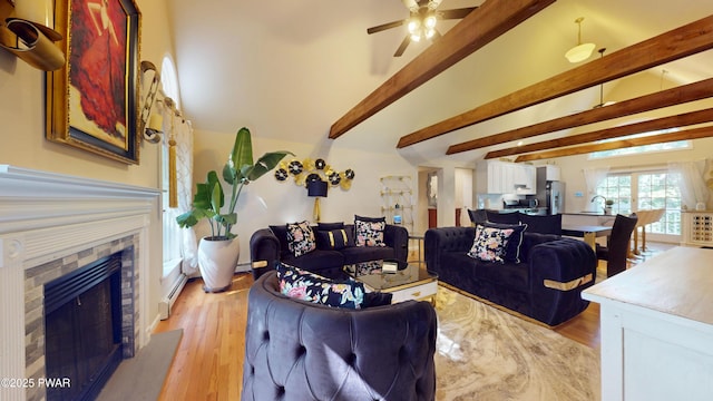 785 Milford Rd, Dingmans Ferry, PA 18328 - living room featuring beamed ceiling, a ceiling fan, a fireplace, light wood-type flooring, and a baseboard heating unit