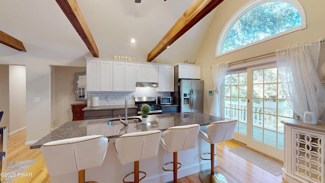 785 Milford Rd, Dingmans Ferry, PA 18328 - kitchen featuring appliances with stainless steel finishes, under cabinet range hood, beam ceiling, backsplash, and white cabinets