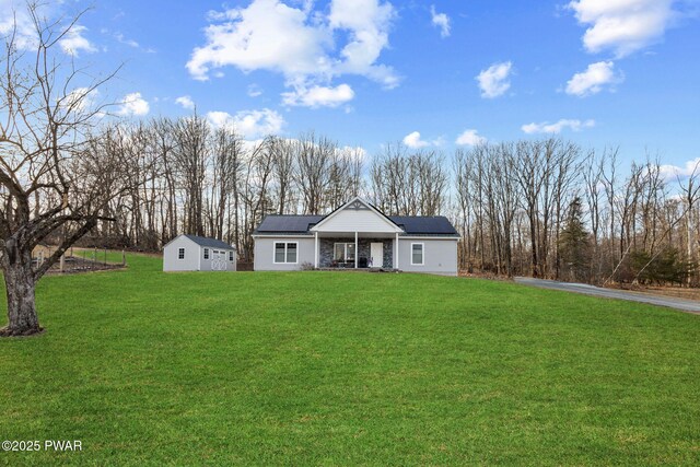 ranch-style home with solar panels, covered porch, and a front yard