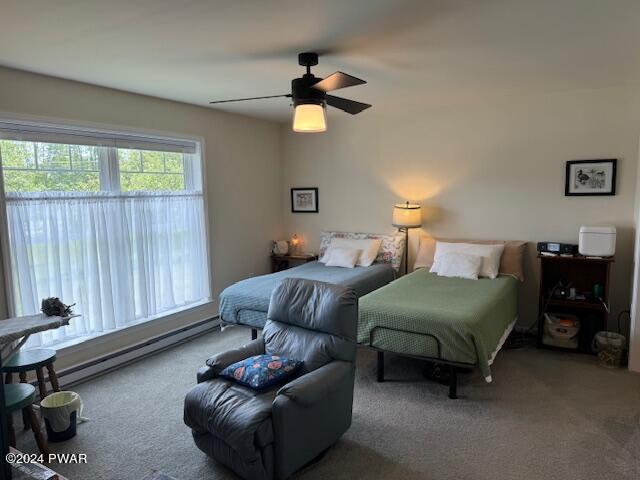 bedroom with carpet, ceiling fan, and a baseboard heating unit