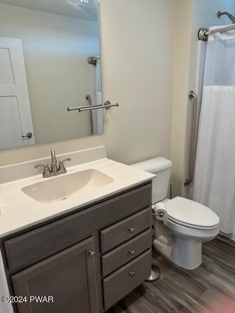 bathroom with hardwood / wood-style floors, vanity, toilet, and a shower with curtain