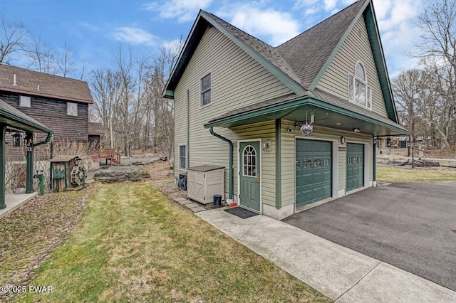 view of home's exterior featuring a yard, an attached garage, and aphalt driveway