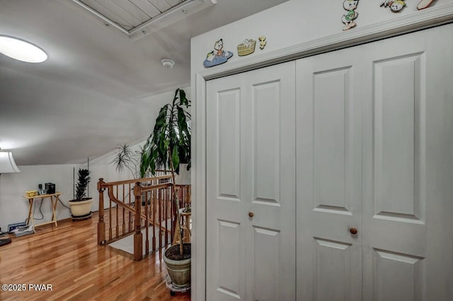 interior space featuring vaulted ceiling, attic access, and wood finished floors
