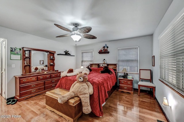 bedroom with light wood-style flooring, ceiling fan, and baseboards