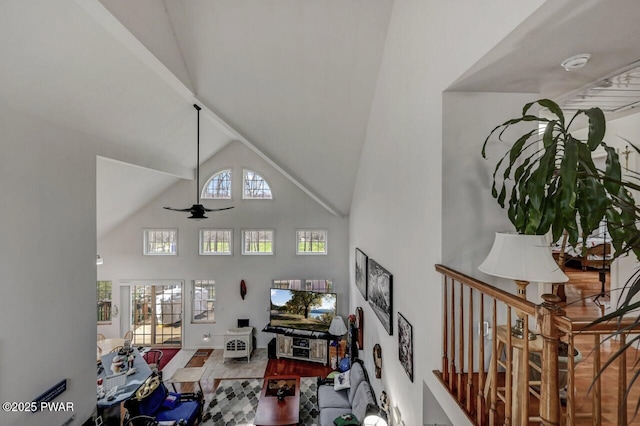 living area featuring ceiling fan and high vaulted ceiling