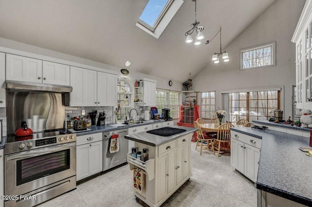 kitchen featuring a skylight, appliances with stainless steel finishes, dark countertops, and open shelves